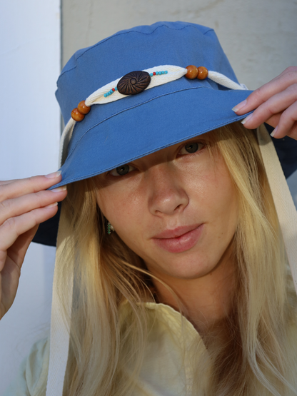 Woman wearing a blue midi sun hat with decorative elements, made in SA