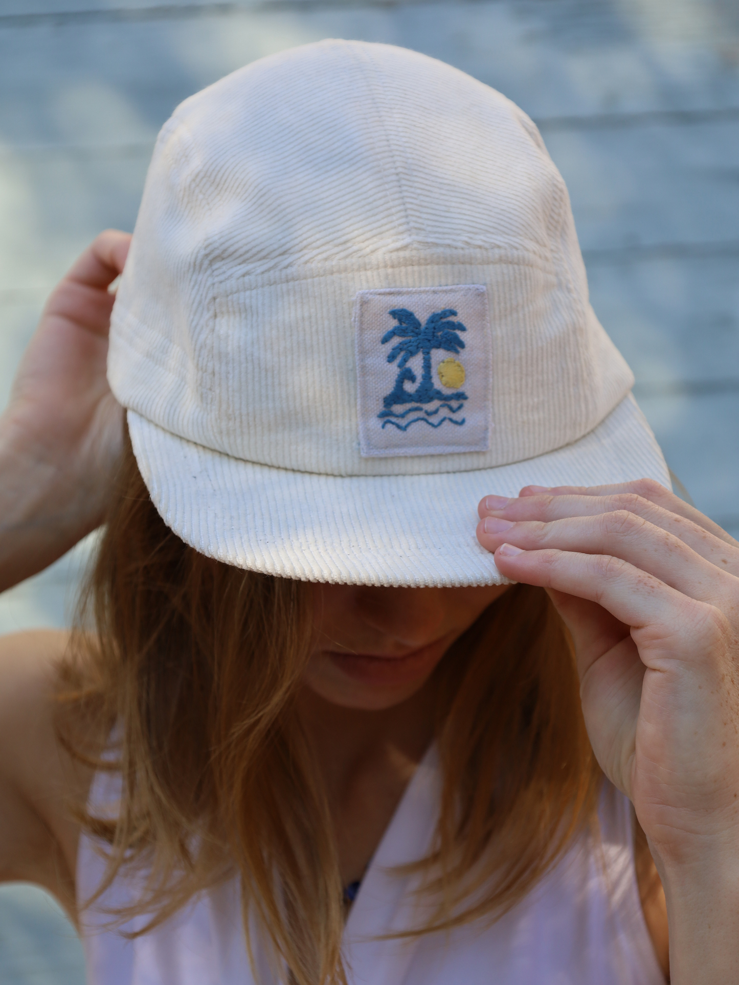 Cream corduroy cap with blue and yellow embroidery
