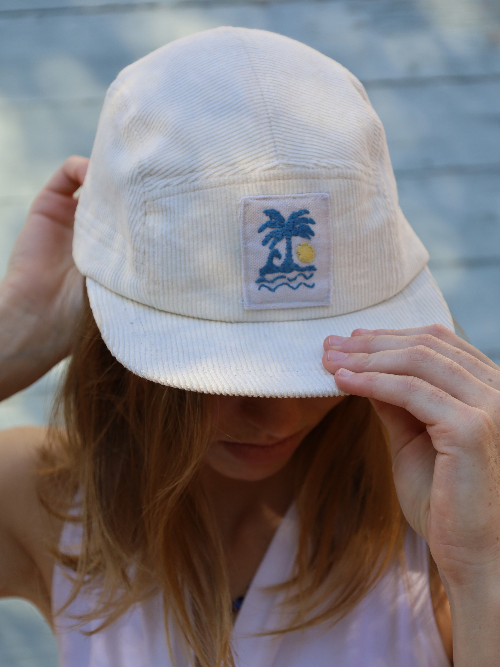 Cream corduroy cap with blue and yellow embroidery