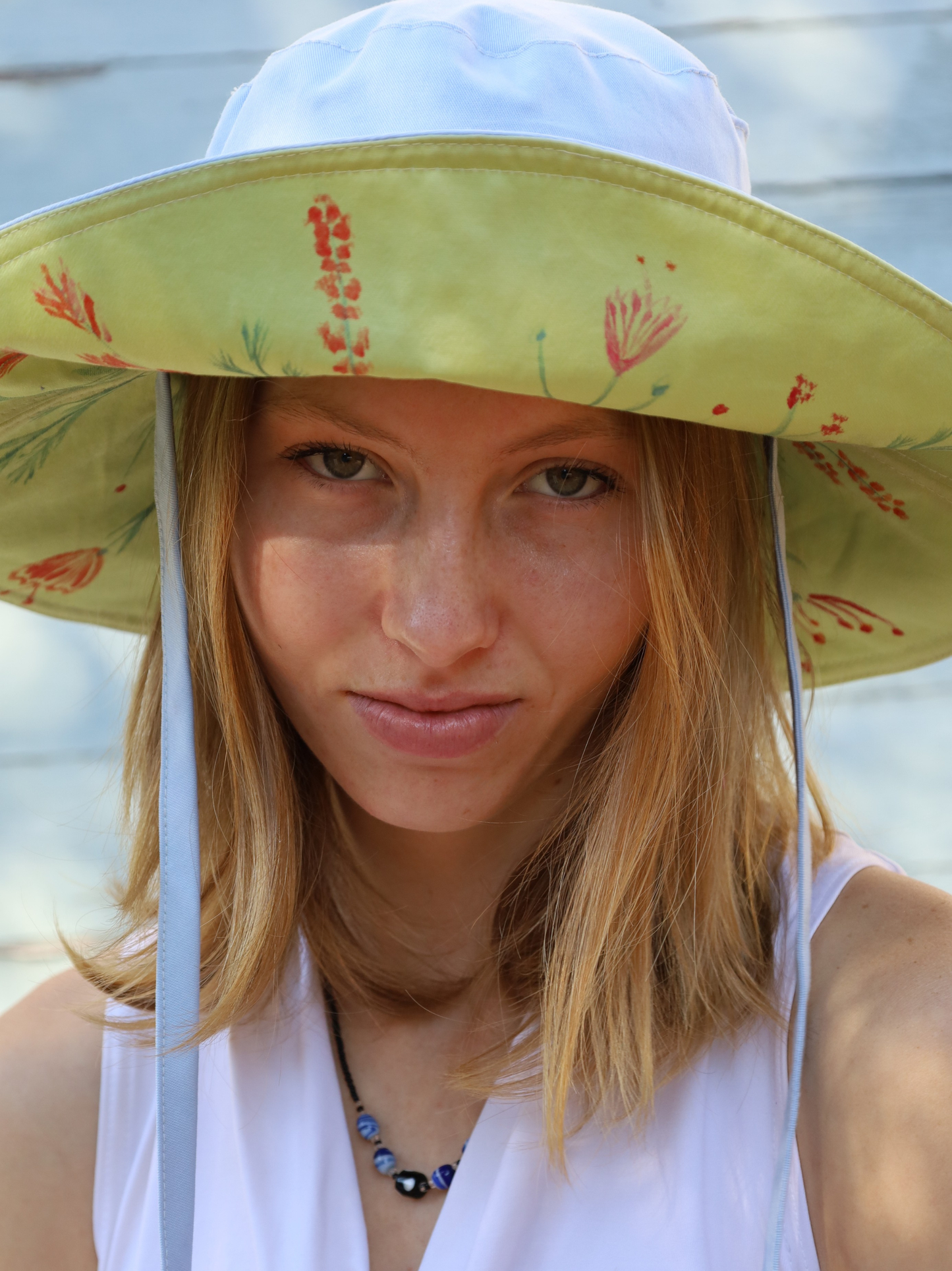 Blue sun hat with a green brim and hand painted flowers. Made in SA