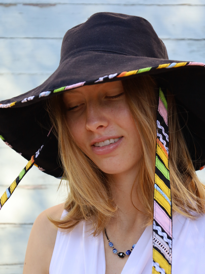 Black wide brimmed sun hat with multi-coloured chin straps and detailing