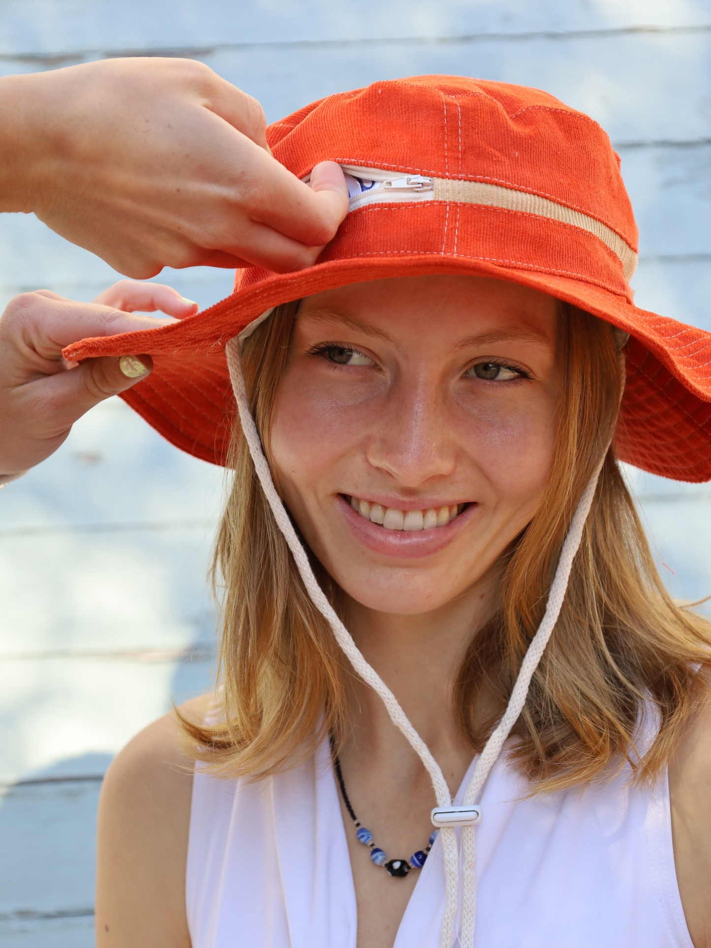 Orange corduroy hat with a zip pocket
