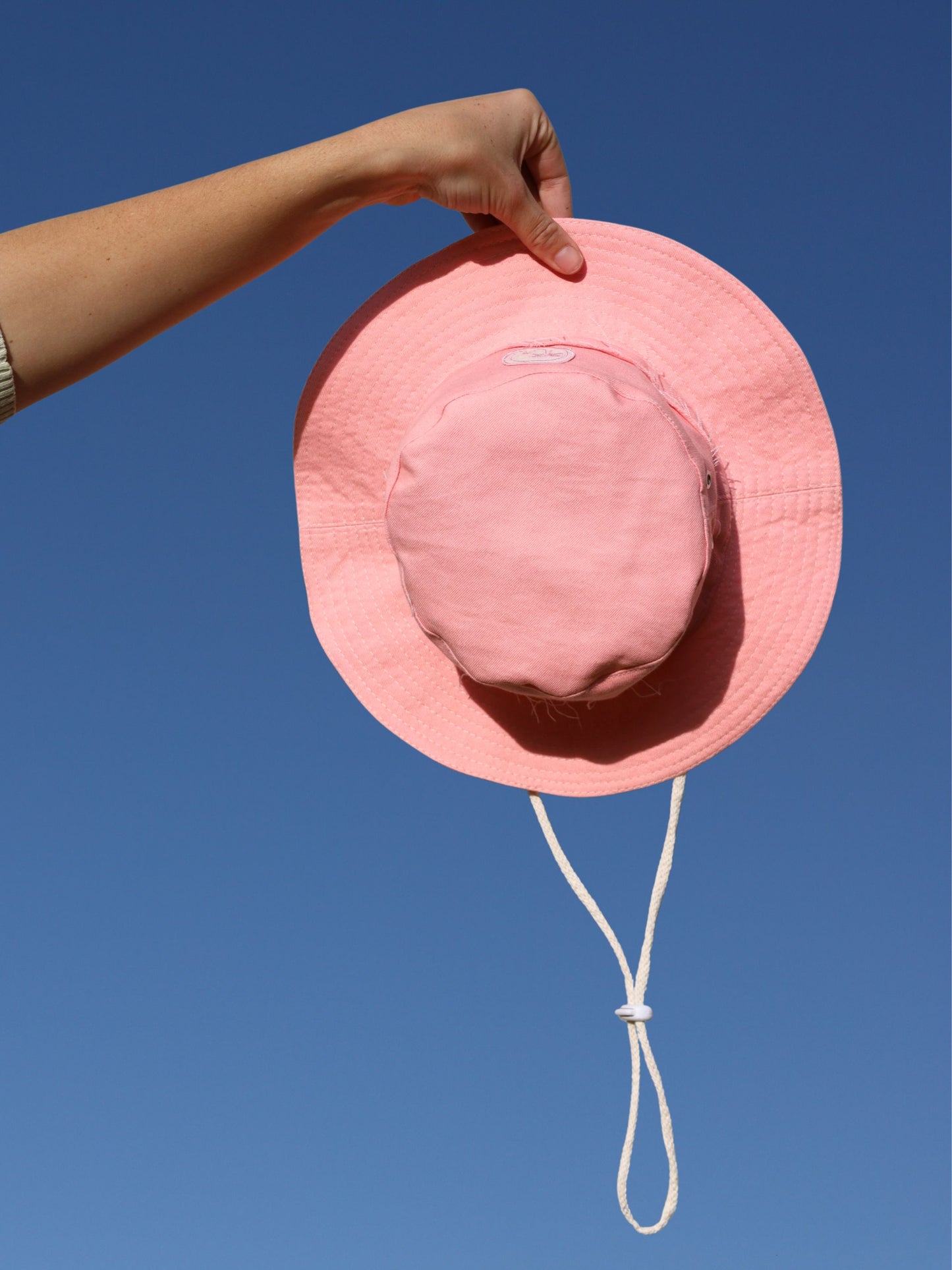 Wide brimmed Fishermen hat in a peach pink colour by morals the brand