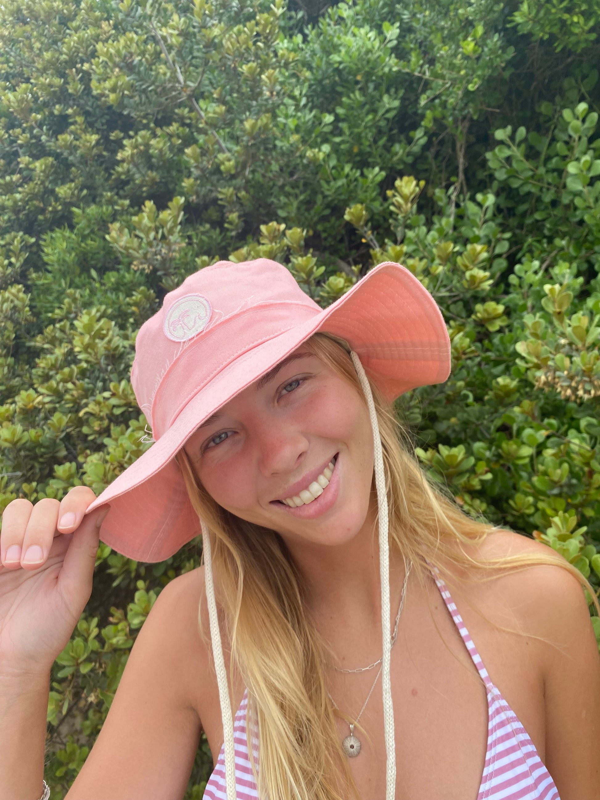 Fabric hat in peach pink with toggle and string